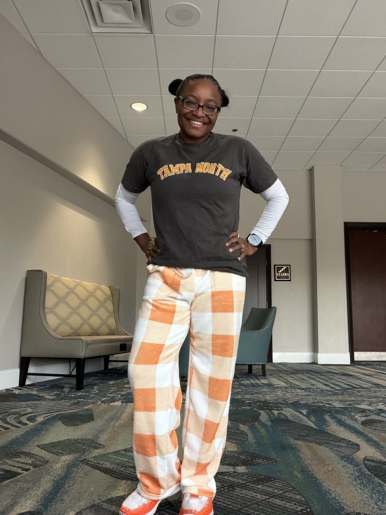Alva on pajama day at a tournament, in a club T-shirt and plaid pajama pants.