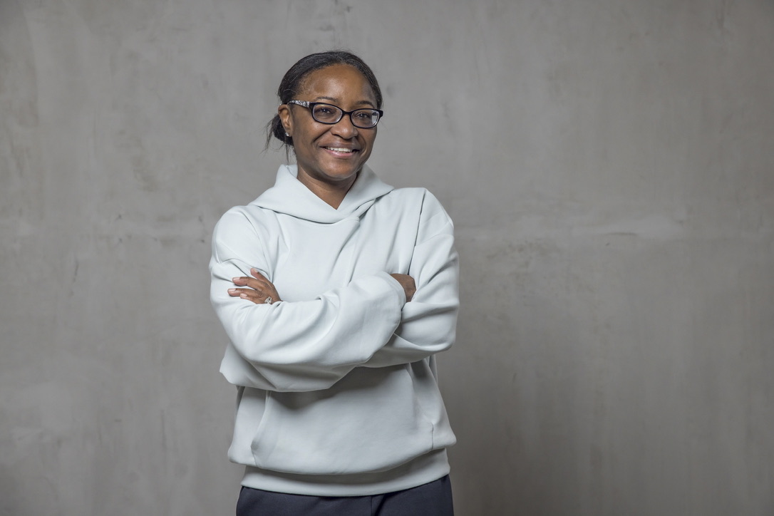 Alva Crawford, who built the Get Seen Playbook, smiling with her arms crossed.